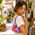 Woman wearing a colorful handmade bandana hobo shoulder bag with a short purple handle.